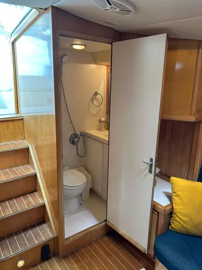 El Caiman Yacht Photos Pics Interior of 1994 Bertram 46 Moppie yacht showing bathroom and wooden stairs.