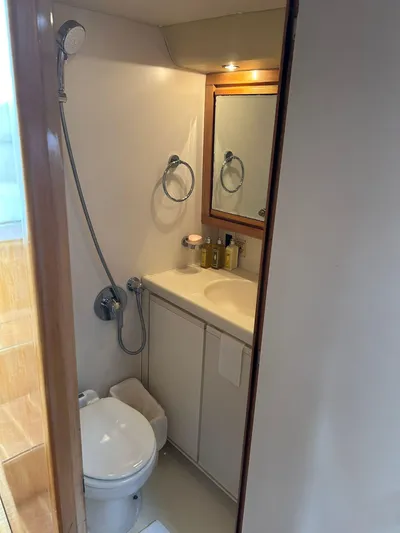 El Caiman Yacht Photos Pics Bathroom interior of 1994 Bertram 46 Moppie yacht with shower, toilet, and vanity.