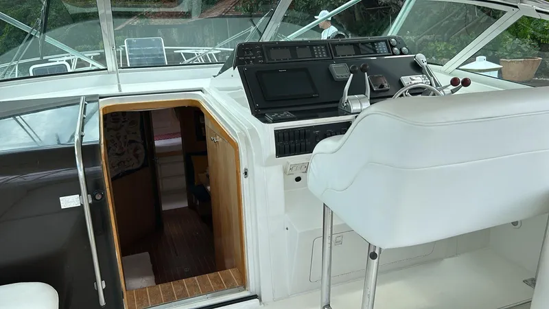 El Caiman Yacht Photos Pics Interior view of 1994 Bertram 46 Moppie yacht cockpit with helm and cabin entrance.