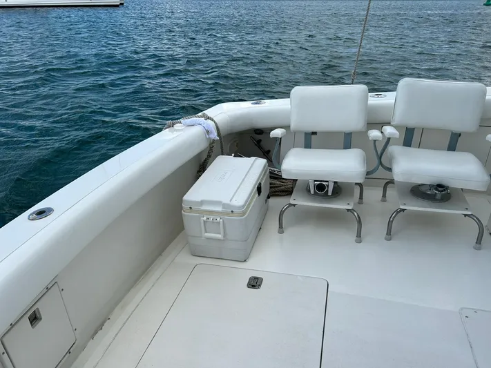El Caiman Yacht Photos Pics 1994 Bertram 46 Moppie boat deck with chairs and cooler by the water.