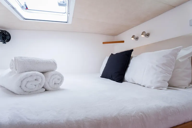 Osprey Yacht Photos Pics Cozy cabin interior of 2010 Voyage 520 yacht with plush bedding and rolled towels.