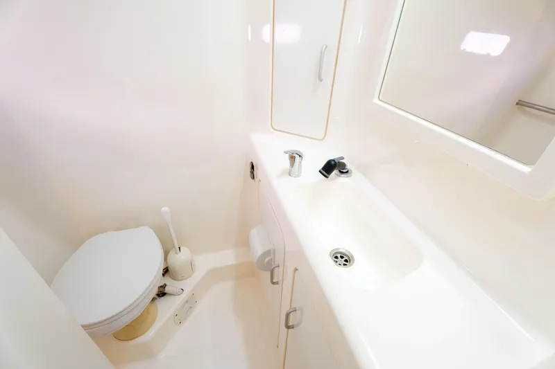 Osprey Yacht Photos Pics Compact bathroom in 2010 Voyage 520 yacht with toilet, sink, and mirror.