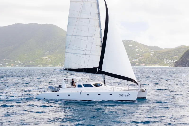 Osprey Yacht Photos Pics Sailing catamaran Voyage 520, 2010 model, cruising near lush green islands.