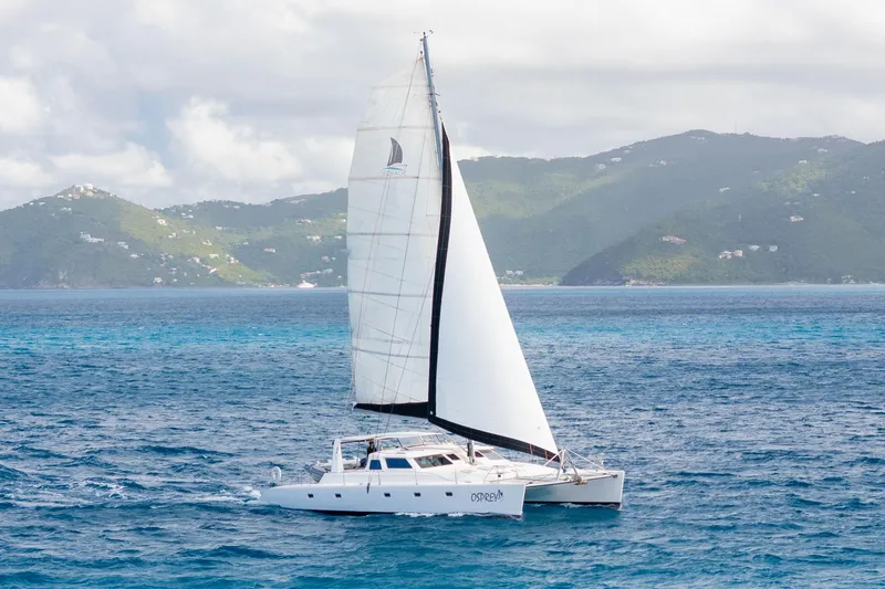Osprey Yacht Photos Pics Sailing catamaran Voyage 520, 2010 model, cruising in tropical waters with lush green islands.