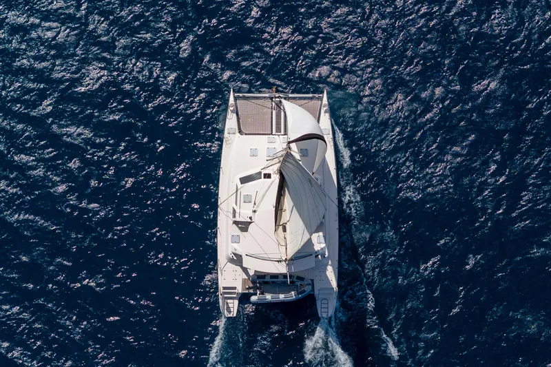 Osprey Yacht Photos Pics Aerial view of 2010 Voyage 520 catamaran sailing on deep blue ocean waters.