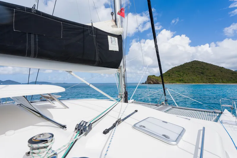 Osprey Yacht Photos Pics Sailing yacht Voyage 520, 2010 model, cruising near a lush island under a clear blue sky.