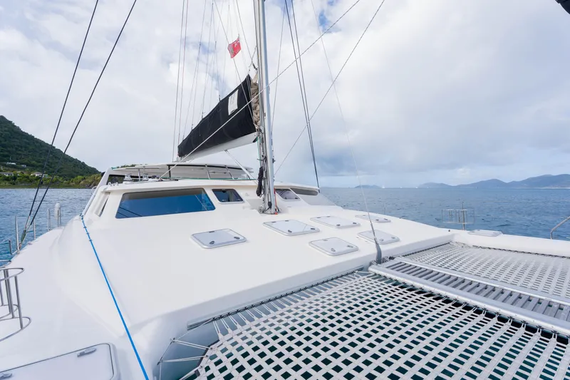 Osprey Yacht Photos Pics Sailing catamaran Voyage 520, 2010 model, on open sea with mountainous backdrop.