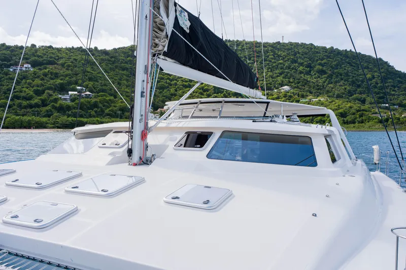 Osprey Yacht Photos Pics Sailing yacht Voyage 520, 2010 model, on calm waters with lush green hills in the background.