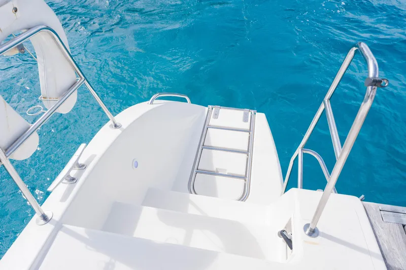 Osprey Yacht Photos Pics Stainless steel boat ladder on Voyage 520, 2010 model, against clear blue water.