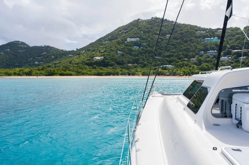 Osprey Yacht Photos Pics Sailing on a 2010 Voyage 520 yacht near a lush, mountainous coastline.