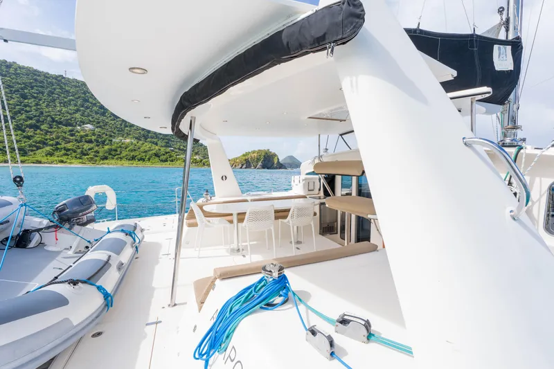 Osprey Yacht Photos Pics 2010 Voyage 520 yacht with spacious deck, anchored near lush green island.