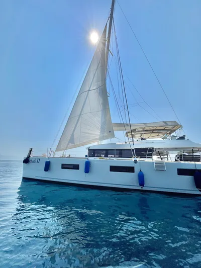  Yacht Photos Pics 2018 Lagoon 620 catamaran sailing on clear blue water under a bright sun.