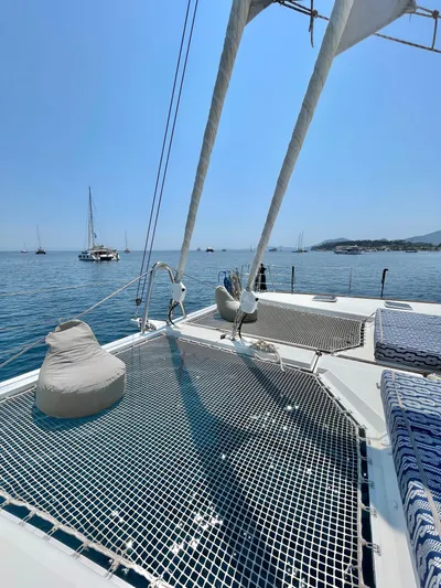  Yacht Photos Pics Lagoon 620 catamaran deck with netting, 2018 model, anchored in serene blue waters.