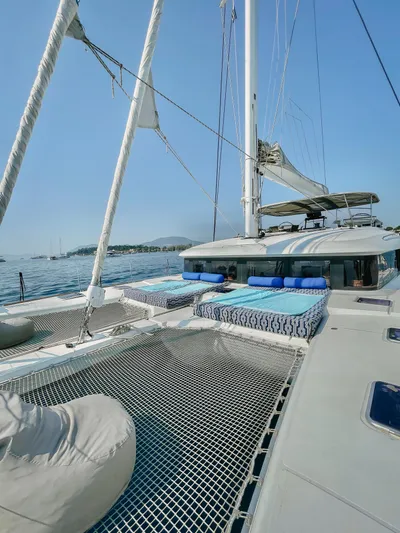  Yacht Photos Pics Lagoon 620 catamaran, 2018 model, with sunbathing nets and cushions, sailing on a clear day.