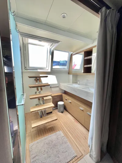  Yacht Photos Pics 2018 Lagoon 620 yacht bathroom with wooden accents and modern fixtures.