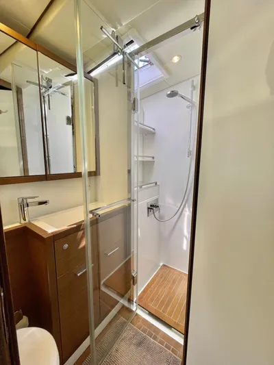  Yacht Photos Pics Modern bathroom in 2018 Lagoon 620 yacht with glass shower and wooden accents.