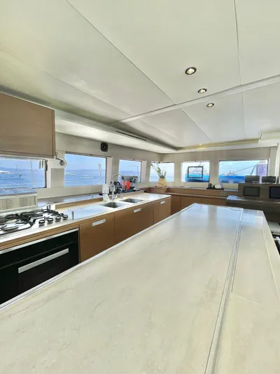  Yacht Photos Pics Luxurious interior of 2018 Lagoon 620 yacht with modern kitchen and panoramic windows.