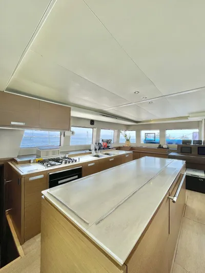  Yacht Photos Pics Spacious interior of 2018 Lagoon 620 yacht with modern kitchen and panoramic windows.