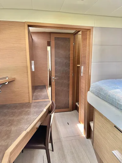  Yacht Photos Pics Interior of 2018 Lagoon 620 yacht featuring modern wood finishes and cozy sleeping area.