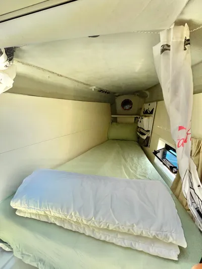  Yacht Photos Pics Cozy cabin interior of 2018 Lagoon 620 yacht with bed and curtains.