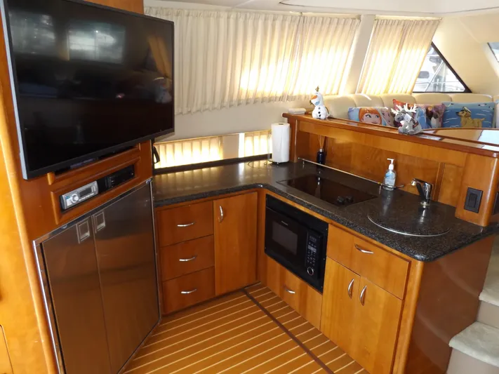  Yacht Photos Pics 2003 Carver 360 Sport Sedan kitchen with wood cabinetry, microwave, and TV.