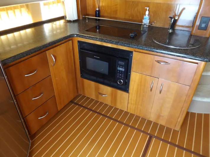  Yacht Photos Pics 2003 Carver 360 Sport Sedan kitchen with wood cabinetry, microwave, and sleek countertops.