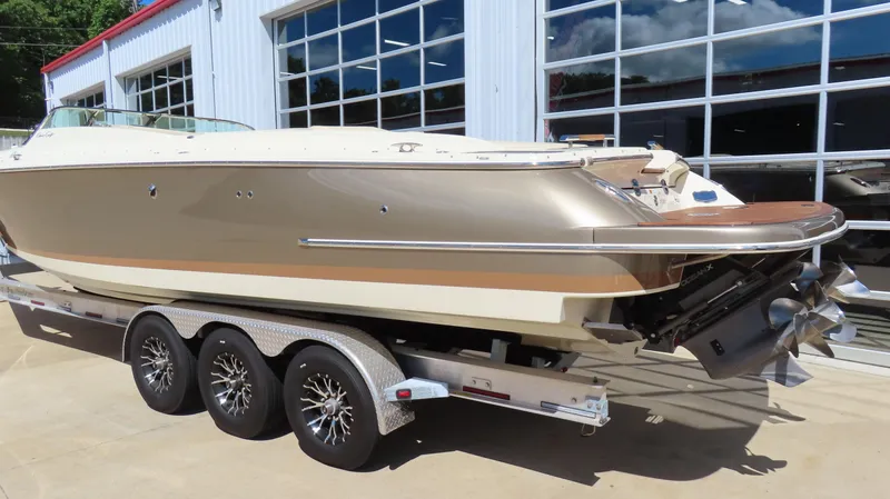  Yacht Photos Pics 2018 Chris-Craft Launch 34 boat on trailer, parked outside a garage.