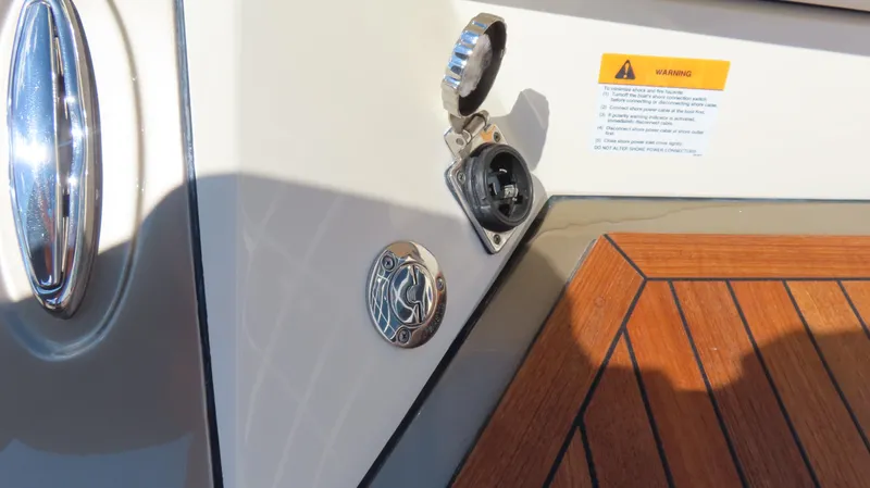  Yacht Photos Pics 2018 Chris-Craft Launch 34 boat detail with open power socket and warning label.