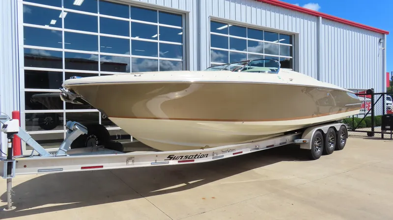  Yacht Photos Pics 2018 Chris-Craft Launch 34 boat on trailer, parked outside a modern building.