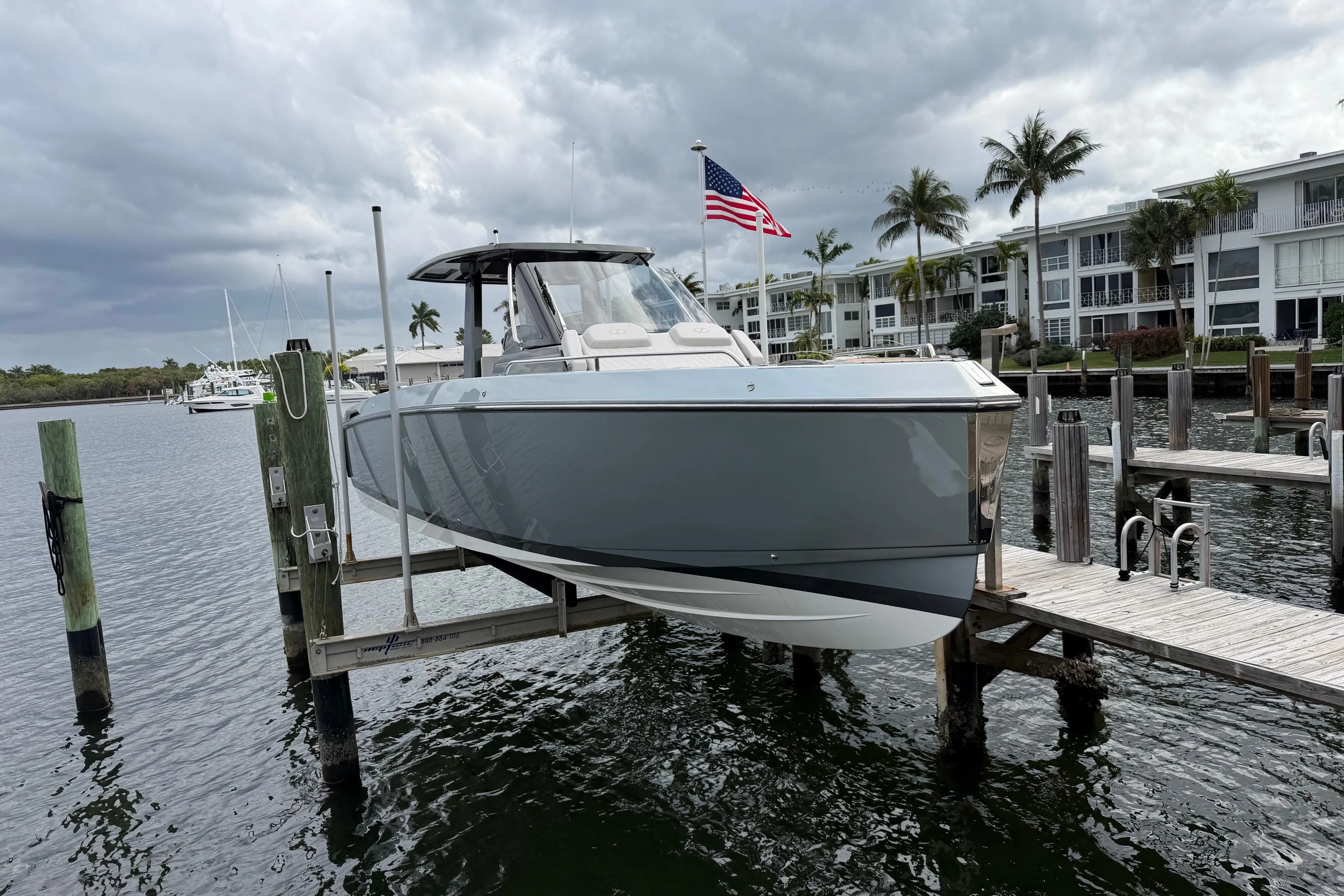 2023 Schaefer V33 boat docked, with American flag, under cloudy skies.
