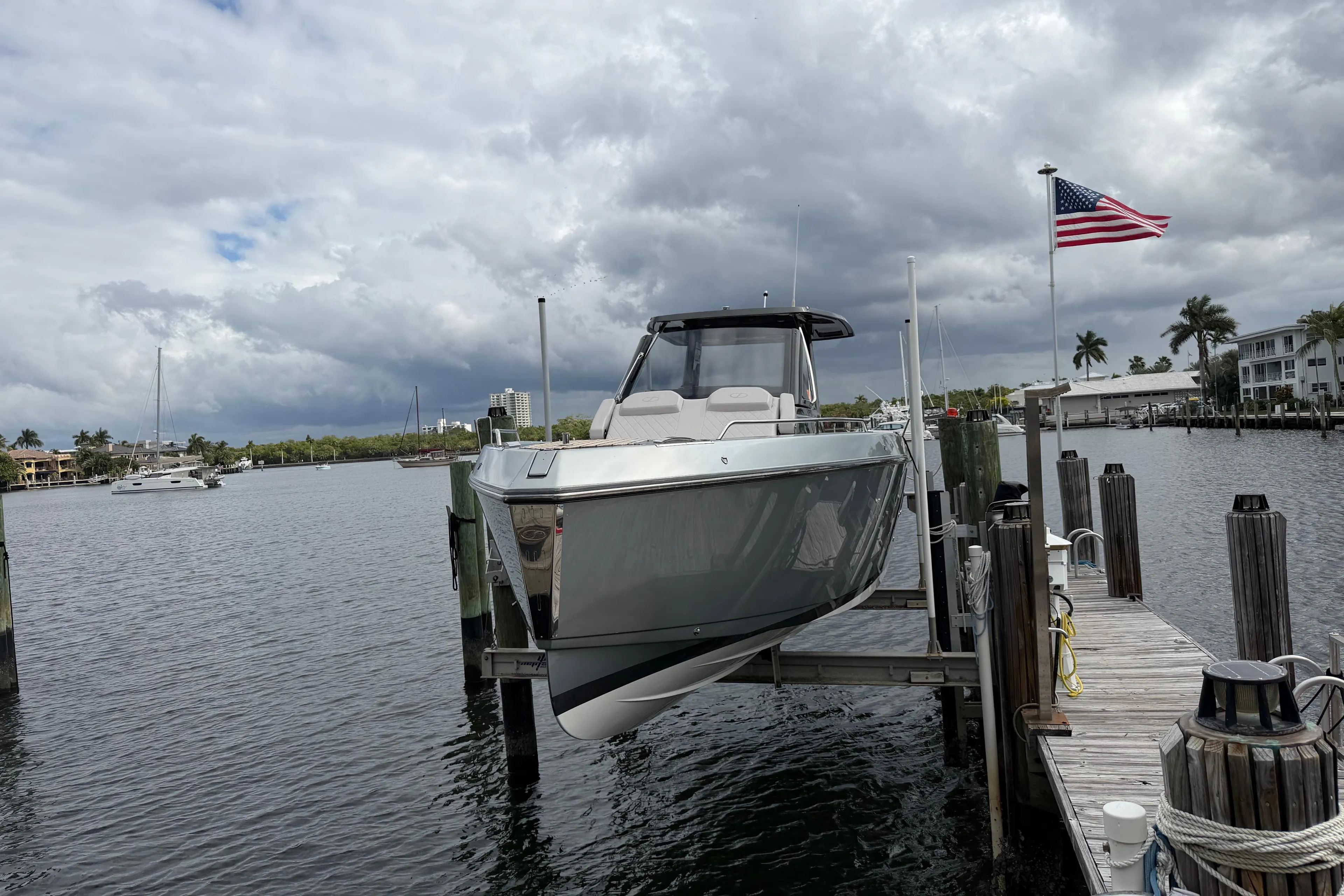2023 Schaefer V33 boat docked at marina with American flag, cloudy sky background.