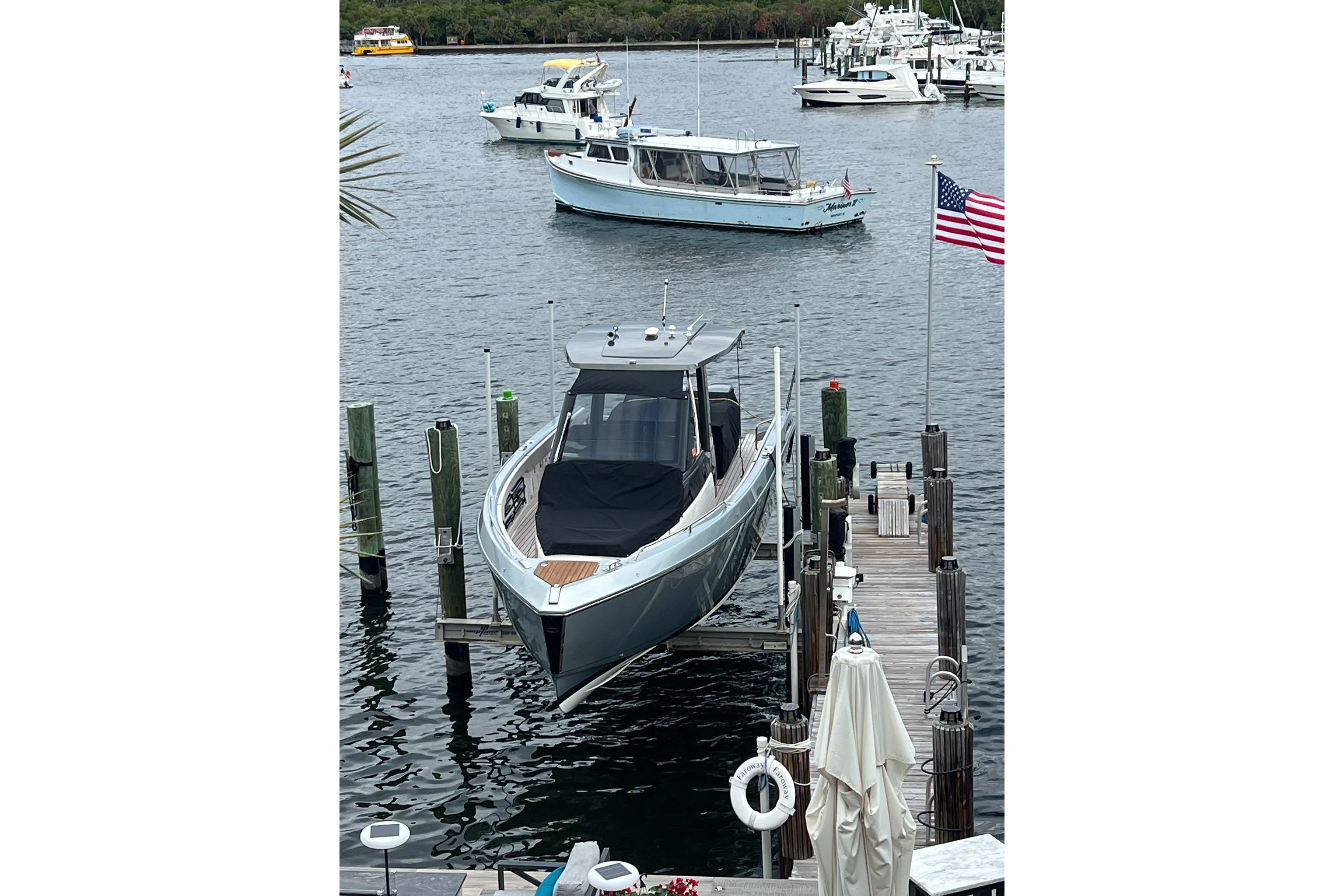 2023 Schaefer V33 boat docked at marina with American flag nearby.