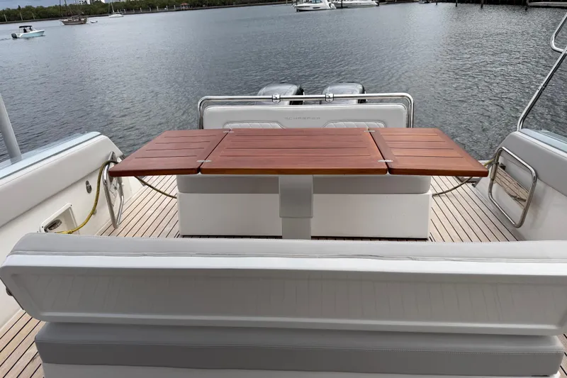  Yacht Photos Pics 2023 Schaefer V33 yacht interior with wooden table and seating, overlooking calm waters.