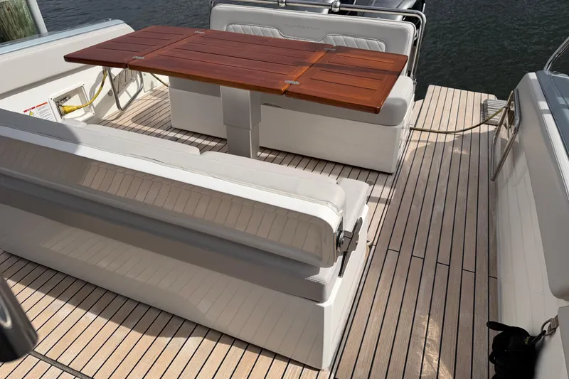  Yacht Photos Pics 2023 Schaefer V33 yacht interior with wooden table and cushioned seating.