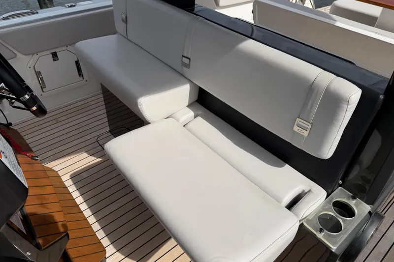  Yacht Photos Pics 2023 Schaefer V33 boat interior with white cushioned seating and wooden flooring.