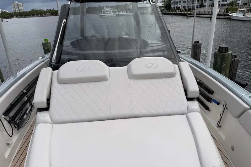  Yacht Photos Pics 2023 Schaefer V33 boat with luxurious white seating, docked by the waterfront.