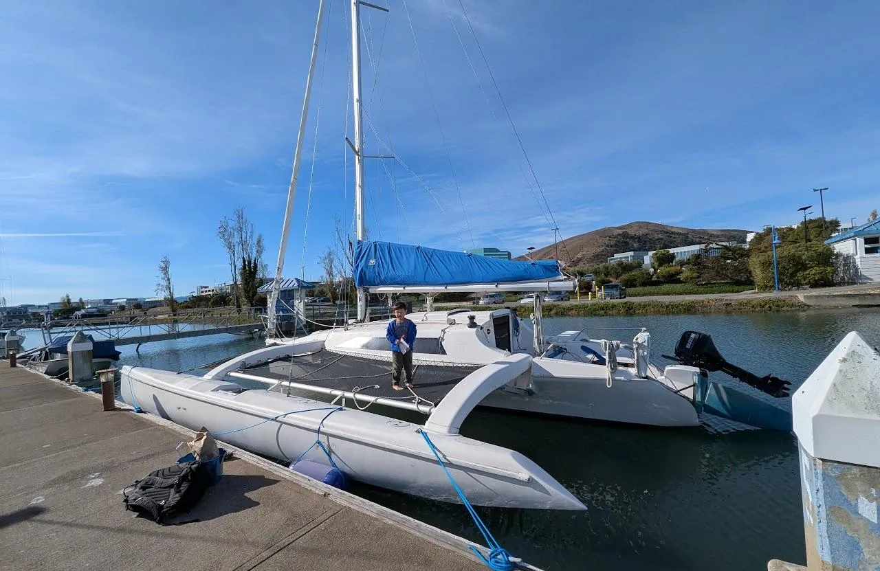 Corsair F-31 trimaran docked at marina, 1996 model, with blue sail cover.