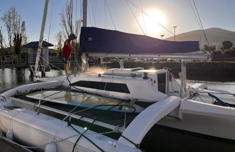 Corsair F-31 trimaran docked at sunset, 1996 model, with person on deck.