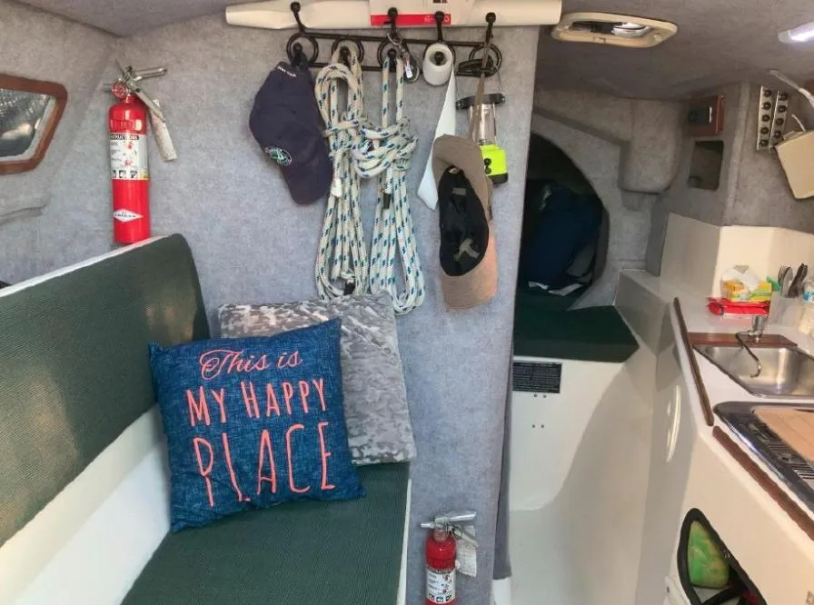 Interior of a 1996 Corsair F-31 sailboat with cozy seating and nautical decor.