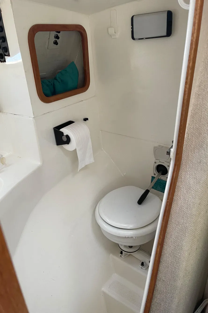 Compact bathroom in 1996 Corsair F-31 sailboat with toilet and storage.