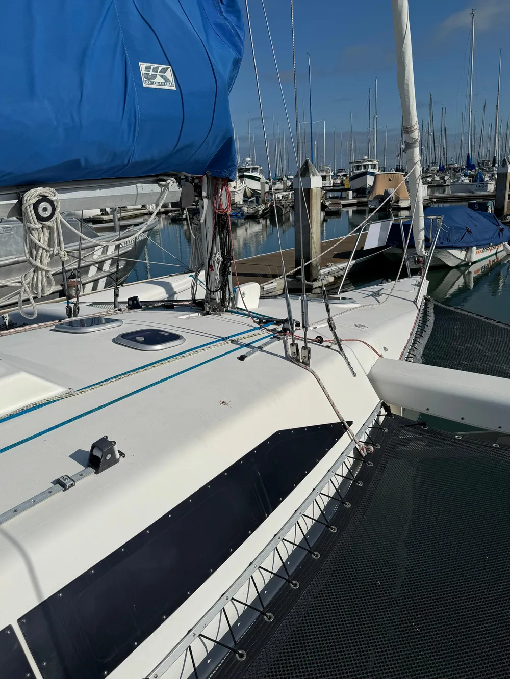 1996 Corsair F-31 sailboat docked in marina, featuring blue sail cover and rigging.