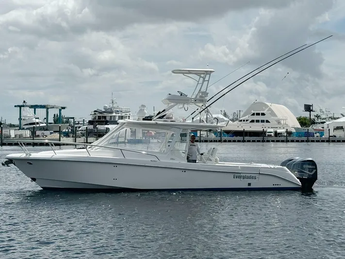 T-party Yacht Photos Pics 2012 Everglades LX 350 boat on water, marina background, cloudy sky.