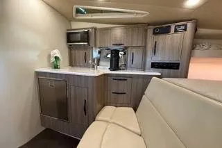 Social Distance Yacht Photos Pics 2019 Regal 35 Sport Coupe interior with modern kitchenette and seating area.
