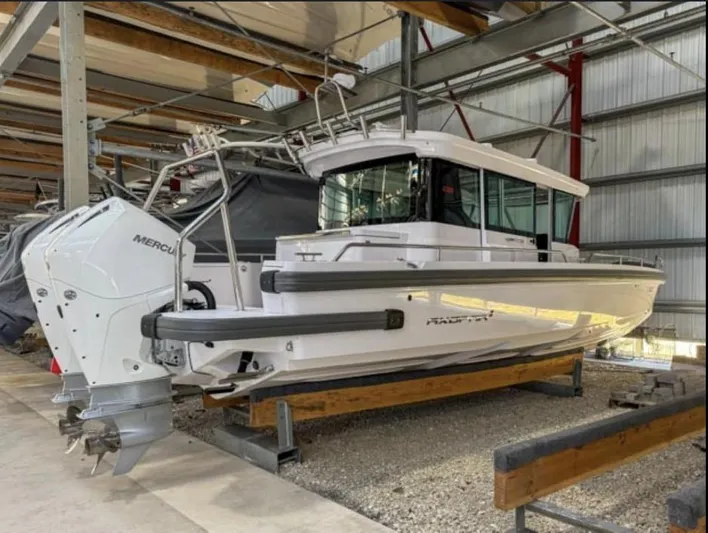  Yacht Photos Pics 2021 Axopar 28 CABIN boat in storage, featuring a sleek design and Mercury outboard engine.