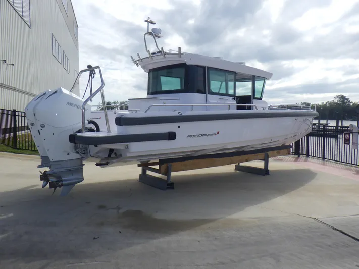 Yacht Photos Pics 2021 Axopar 28 CABIN boat on display, featuring sleek design and modern outboard motor.
