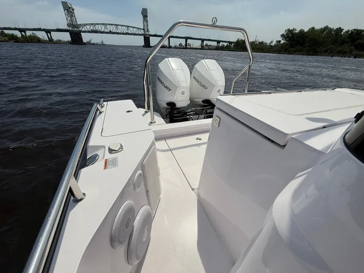  Yacht Photos Pics 2021 Axopar 28 CABIN boat with twin Mercury engines on a river near a bridge.