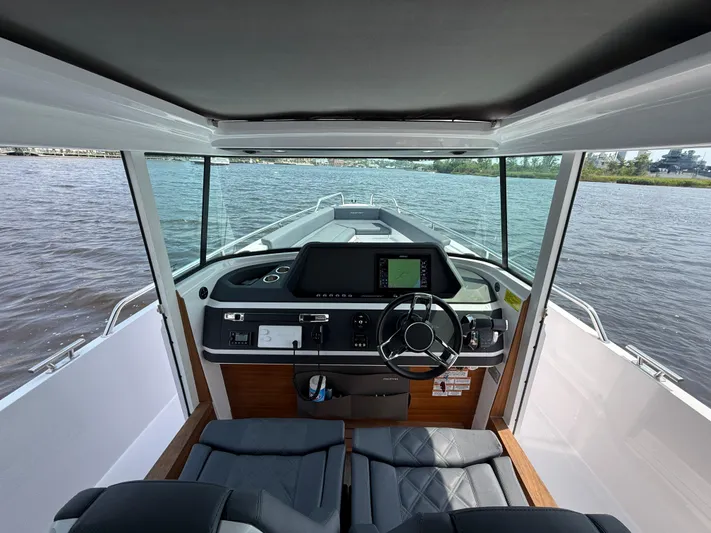  Yacht Photos Pics Interior view of 2021 Axopar 28 CABIN boat with modern dashboard and steering wheel.