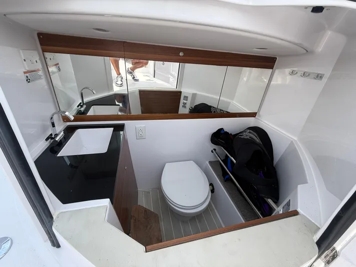  Yacht Photos Pics 2021 Axopar 28 CABIN bathroom with modern fixtures and storage space.