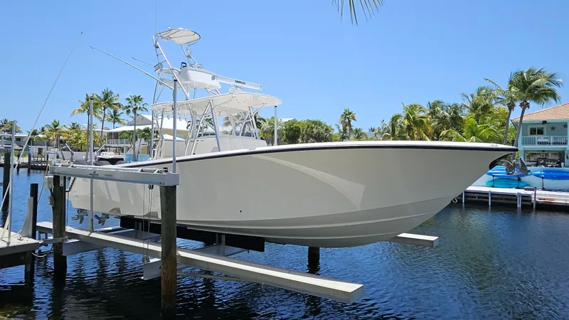  Yacht Photos Pics 2023 SeaVee 370z boat on lift, surrounded by palm trees and waterfront homes.