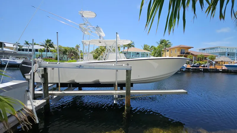  Yacht Photos Pics 2023 SeaVee 370z boat on lift, docked in sunny waterfront setting.